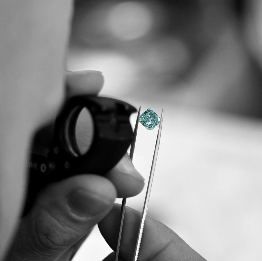 Prüfung eines natürlichen blauen Diamanten unter der Lupe